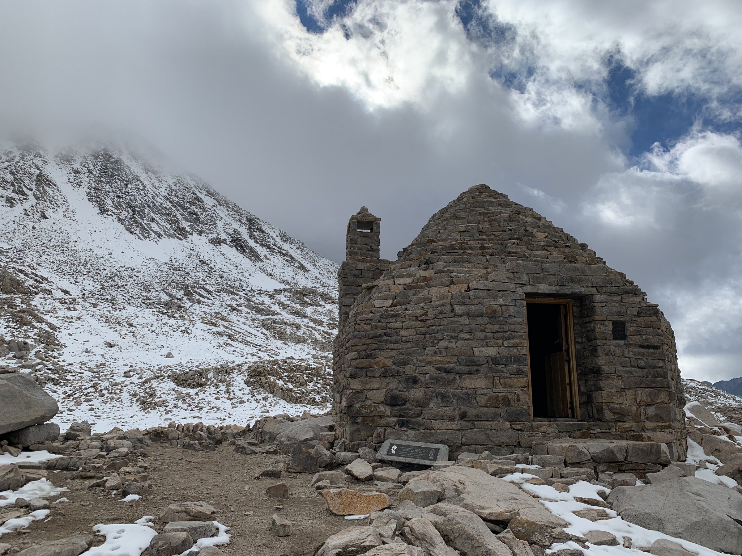 Stone shelter in a snowy mountain basin