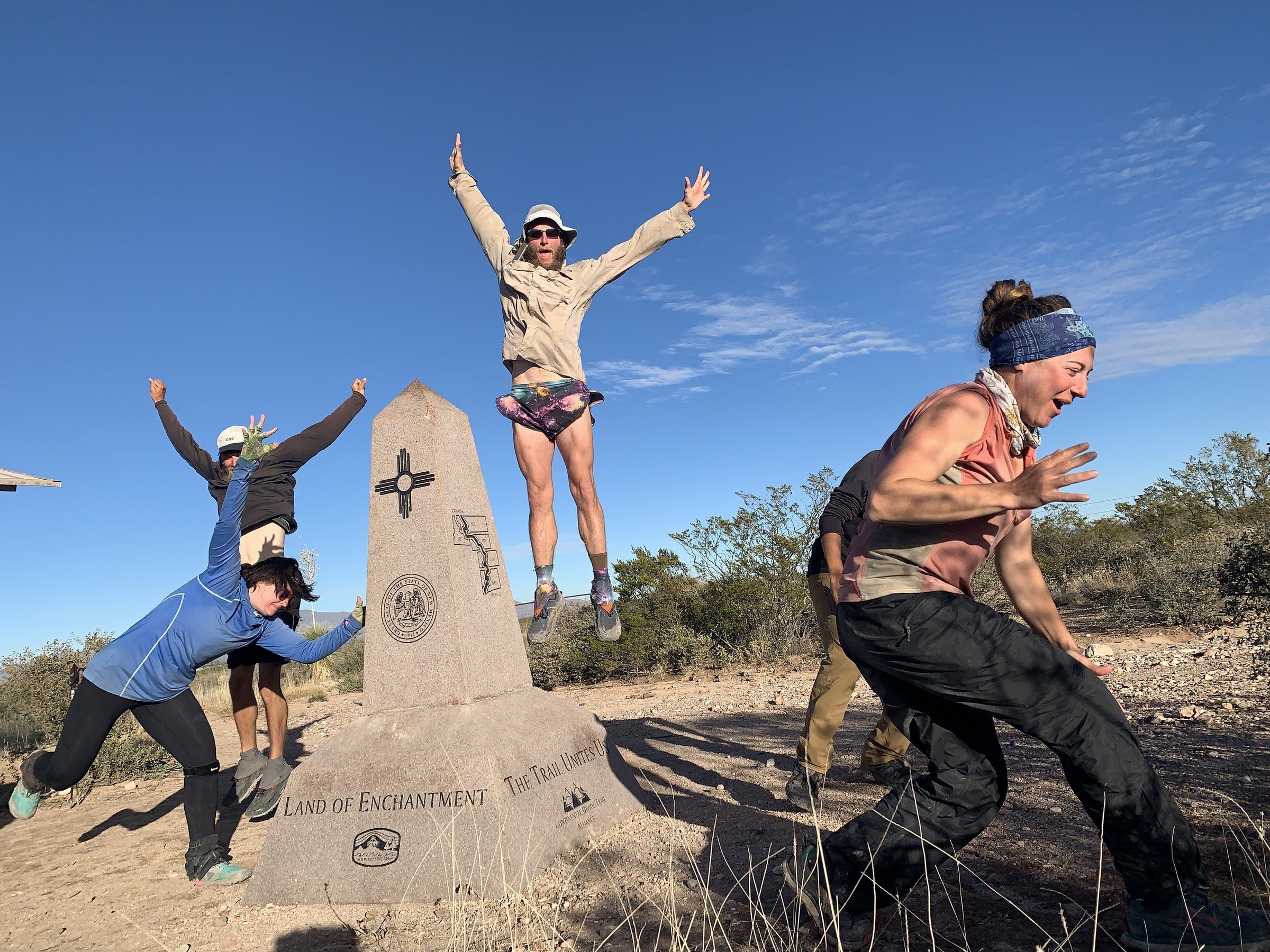 Hiker posing beside a stone border monument