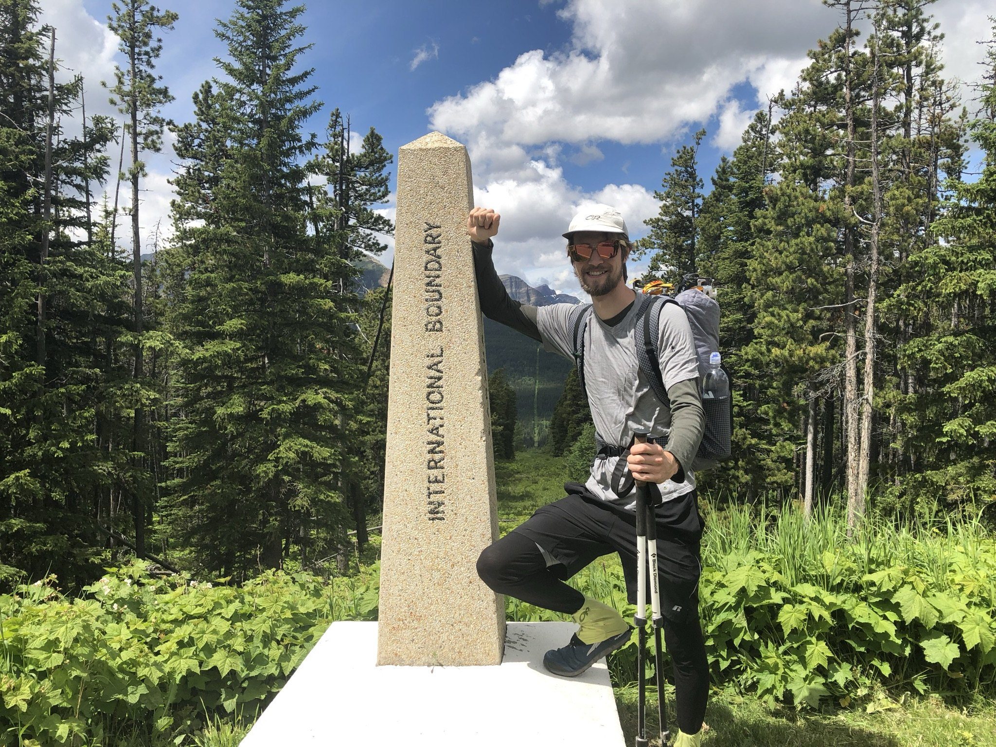 Hiker standing beside a boundary marker