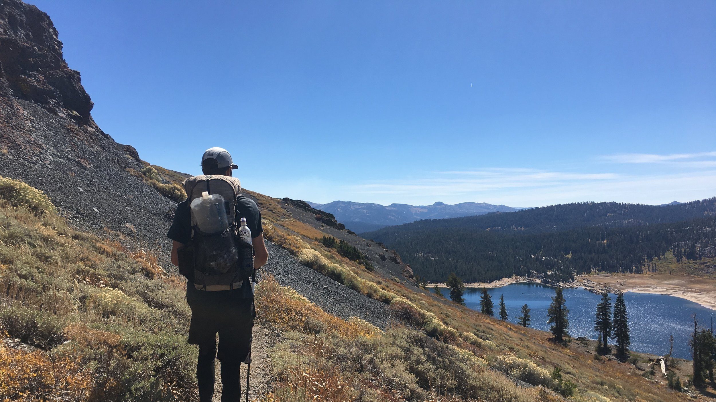 Backpacking gear arranged in mountain country
